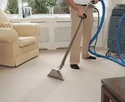 Carpet cleaning professional removing dirt and stains with a hot-water extraction tool in a home, Irvine, CA.