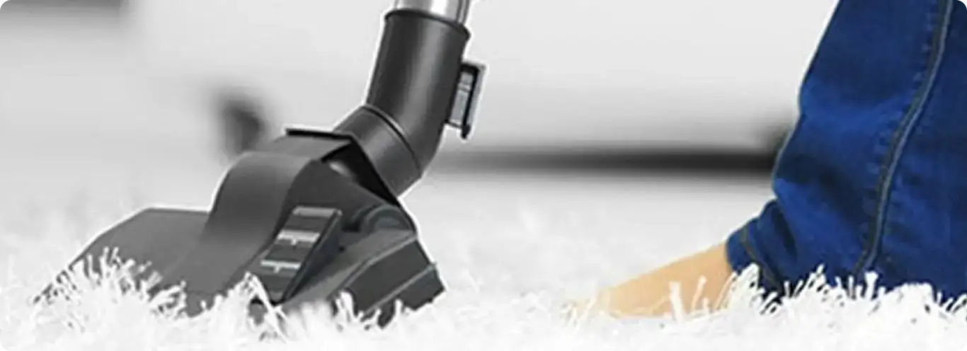 Close-up of a professional vacuuming a white carpet in Santa Ana.