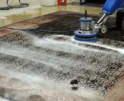Professional rug cleaning with a rotary floor machine and shampoo foam, deep-cleaning an area rug, in Irvine, CA.